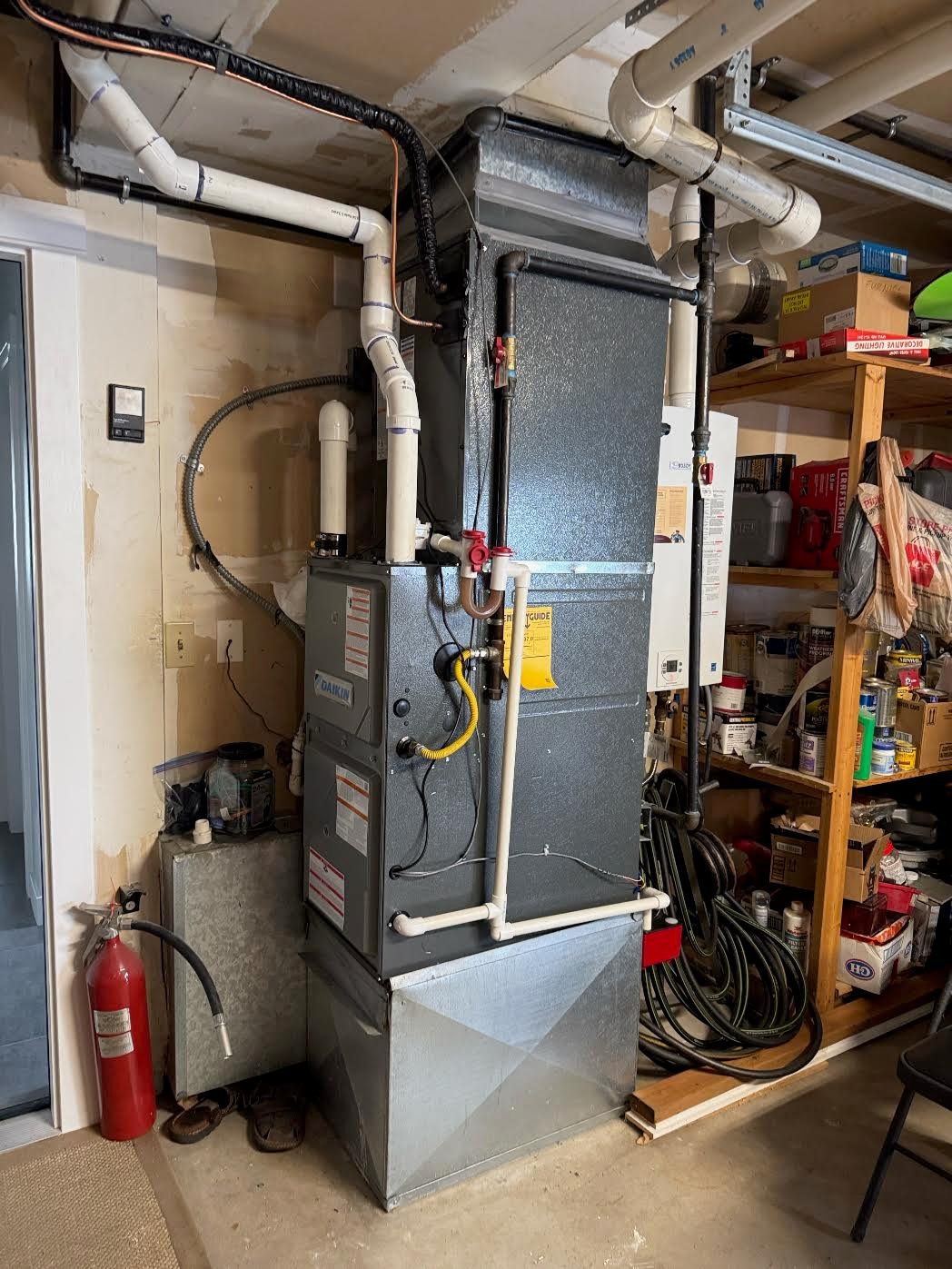 HVAC furnace system in basement with ductwork and electrical components